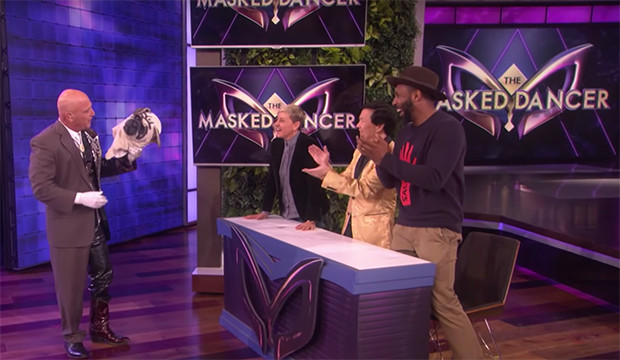 howie mandel with a pug mask in front of a panel of ellen and ken jeong on the masked dancer segment on the talk show
