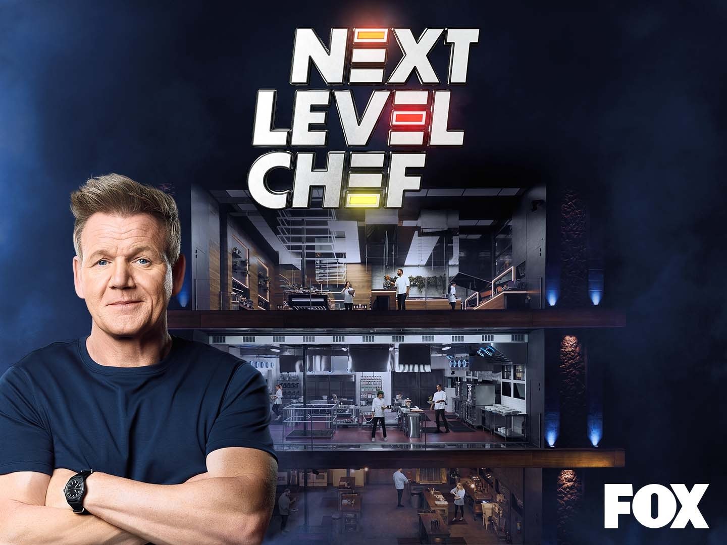 next level chef | FOX 28 Spokane gordon ramsay standing in the forefront wearing a dark t-shirt and a smirk and behind him is the multilevel competition space for his next level chef reality competition