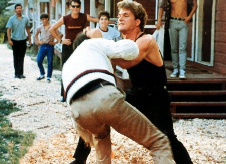 patrick swayze as johnny fights max cantor as robbie in front of the staff cabins in dirty dancing