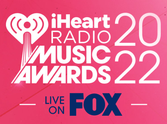 bright pink logo card for iheart radio music awards 2022 airing live on fox 