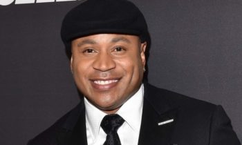 actor and music star ll cool j dressed in a black suit with a white shirt and a black tie and a black hat