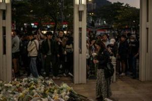Stunned mourners gather outside ruins of Hong Kong housing estate blaze